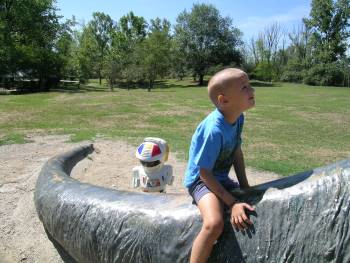 Alessandro e Ta sulla coda del brontosauro al Parco della Preistoria